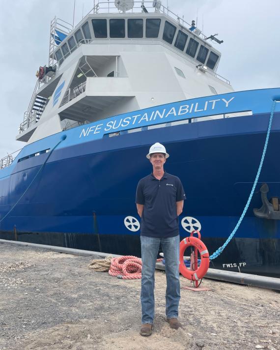 NFE employee standing by a ship